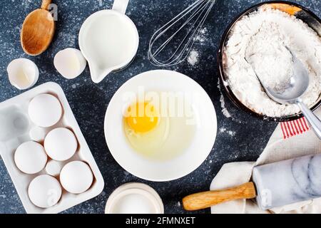 Baking concept. Marble rolling pin with flour and eggs on a dark background Baking background Stock Photo