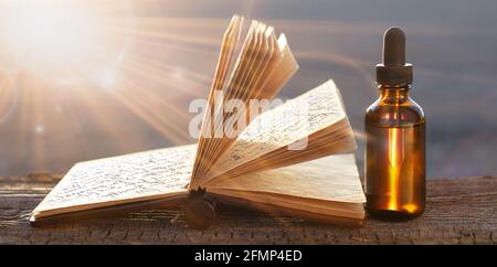 Natural medicine. Herbs, medicinal bottles and old recipe book with copy space. Stock Photo