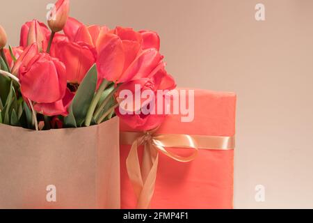 Beautiful red tulips in a gift bag and gift boxes. Congratulatory photo happy birthday, March 8, Mother's Day. Place for text copy space Stock Photo