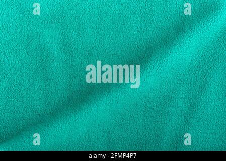 Green fleece background with wave. Surface of fabric, textile Stock Photo