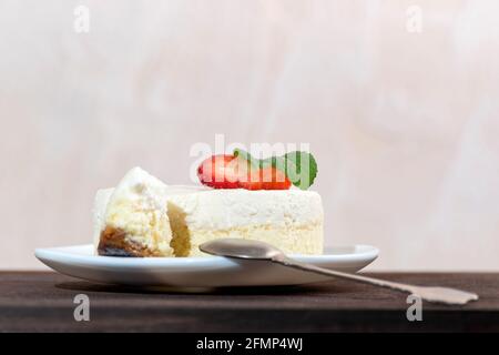 Classical New York cheesecake with slice cut out and dessert spoon Stock Photo