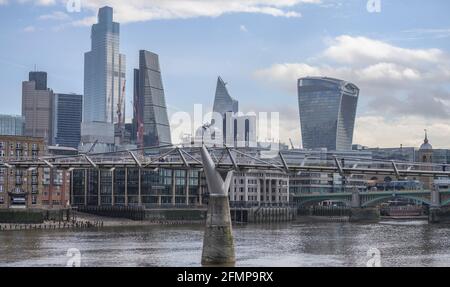 Bankside, London, UK. 11 May 2021. A few pedestrians cross over the Millennium footbridge over the river Thames against a backdrop of the ever changing City of London skyline on a mild day in the capital. Credit: Malcolm Park/Alamy Live News. Stock Photo