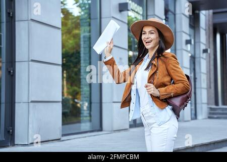 Smiling lady in hat holding map outdoor Stock Photo