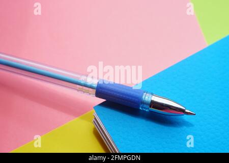 Blue ballpoint pen on happy colored paper. Stock Photo