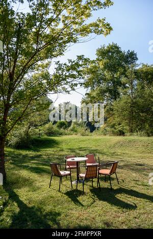 Empty garden table and chairs on green grass at the park Stock Photo
