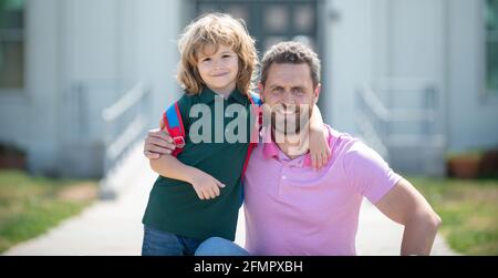 Father and son run with father after come back from school. Family, education and outdoor concept. Stock Photo