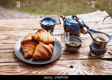 Breakfast with Chinese tea and fresh pastries, aromatic butter croissants. Tea ceremony. Stock Photo