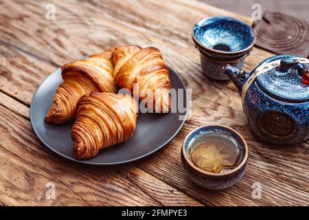 Breakfast with Chinese tea and fresh pastries, aromatic butter croissants. Tea ceremony. Stock Photo