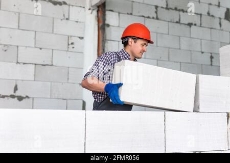 bricklayer man builder working with autoclaved aerated concrete blocks. Walling Stock Photo