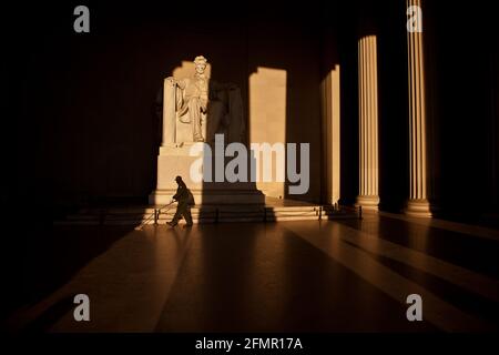 An employee sweeping the floor of the Lincoln Memorial at sunrise, in Washington DC. Stock Photo