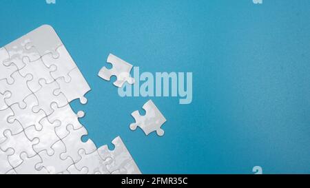 Selective focus of piece of jigsaw puzzle with a blue background Stock Photo
