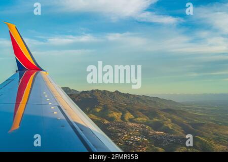 Winglet view of Southwest flight over Oahu Hawaii during sunset Stock Photo