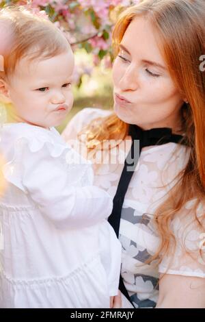 Portrait of a parent mom with a baby daughter grimacing playing face. Stock Photo