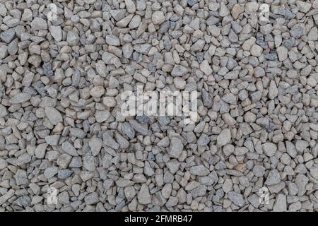 Dry white limestone ballast flat full frame background. Small gray dusty broken macadam stones texture. Viiew from above. Stock Photo