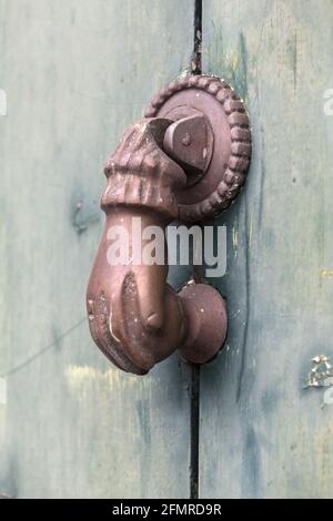 Old rusty door knocker in shape of a hand. Madeira Island, Portugal Stock Photo