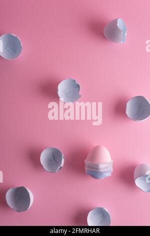 coronavirus Easter egg in a protective mask concept painted in a pink-blue pastel shade eggshell. Minimalistic easter coronavirus concept. Stock Photo