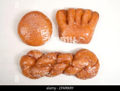 Flat lay top view  of donuts arranged on parchment paper clustered together. Bear Claw, Cinnamon Twist, jelly filled on parchment paper Stock Photo