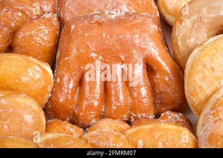 Close up on Variety of donuts arranged on parchment paper clustered together. Bear Claw in the center surrounded by glazed twists, Cinnamon Twist, jel Stock Photo