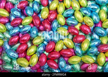 Close up background of Chocolate easter eggs covered with brightly colored foil wrappers Stock Photo