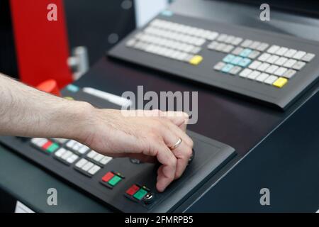 Hand of CNC machine operator on the control panel. Selective focus. Stock Photo