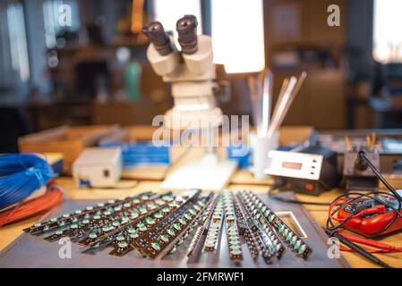 Large electron microscope and panel of LED light indicators are stacked on plate to prepare for the research of electronic components in a laboratory Stock Photo