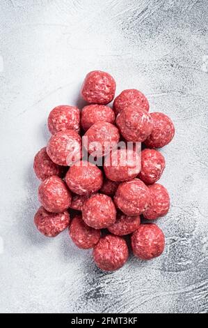 Raw beef and pork meatballs with spices on kitchen table. White background. Top view Stock Photo