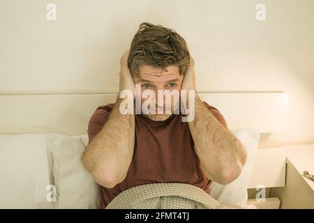Man suffering depression - dramatic portrait at home of sad and depressed guy early 40s lying on bed having anxiety problem feeling desperate and brok Stock Photo