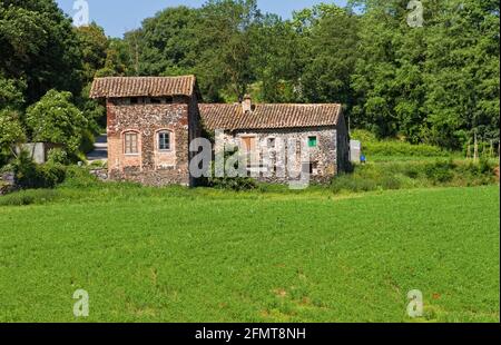 Typical Catalan countryside, rural grass with your mower, straw waltz and the church, surrounded by mountains Stock Photo