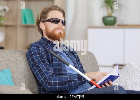 blind man reading book on the sofa Stock Photo