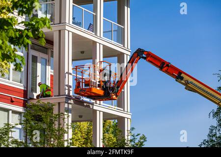 Construction worker using a man-lift to reach an upper balcony in Steveston British Columbia Canada Stock Photo