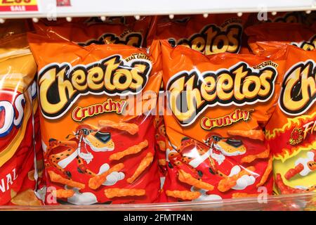 Crunchy Cheetos shot closeup that's bright and colorful  on a metal shelf at a grocery store in Kansas. Stock Photo