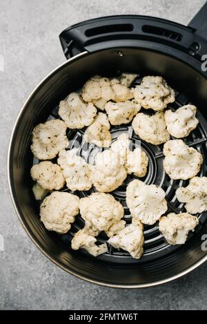 Raw cauliflower in an air fryer ready to be cooked Stock Photo