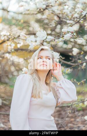 gentle blonde in a beige dress in the park Stock Photo