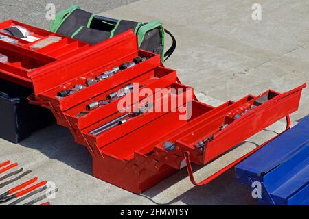 Open professional metal storage tool box on pavement Stock Photo