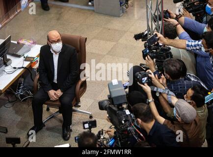 Tehran, Iran. 11th May, 2021. Former Iranian Defense Minister Hossein Dehghan (L) is surrounded by media as he registers his candidacy for the 13th presidential race at the Interior Ministry in Tehran, Iran, on May 11, 2021. Iran's Ministry of Interior Affairs on Tuesday officially started registering candidates for the 13th presidential race, state TV reported. Credit: Ahmad Halabisaz/Xinhua/Alamy Live News Stock Photo