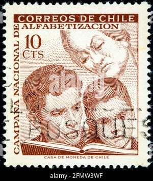 CHILE - CIRCA 1966: A stamp printed in Chile from the 'Education Campaign' issue shows learning, circa 1966 Stock Photo