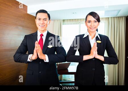 Portrait of hotel staff greeting with hands put together Stock Photo