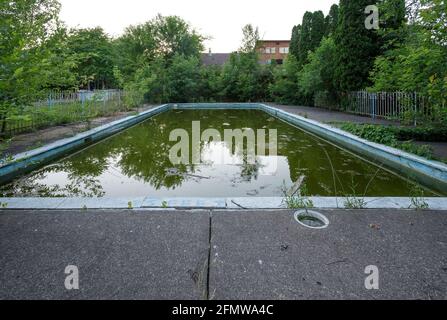 A very dirty outdoor swimming pool at an abandoned motel. Stock Photo