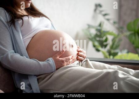 pregnant woman with big belly advanced pregnancy resting sitting on sofa at home.Healthy pregnancy and happy moterinty Stock Photo