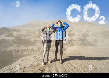 Young couple man and woman scared of CO2 lettering made of clouds. Sky with CO2 pollution, smog Stock Photo