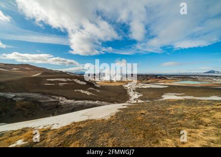 Namafjall Hverir geothermal area in Iceland. Stunning landscape of sulfur valley with smoking fumaroles and blue cloudy sky, travel background Stock Photo