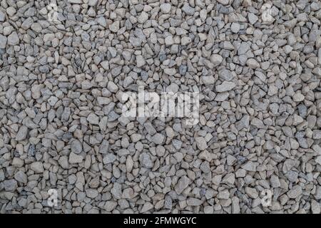 Dry white limestone ballast flat full frame background. Small gray dusty broken macadam stones texture. Viiew from above. Stock Photo