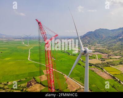 Wind turbine being repaired, assisted by crane and elevator. Wind power plant. green meadow with Wind turbines generating electricity Stock Photo