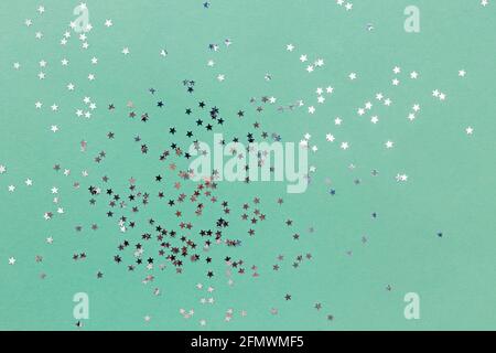 Star shaped glitter confetti on pastel green background Stock Photo