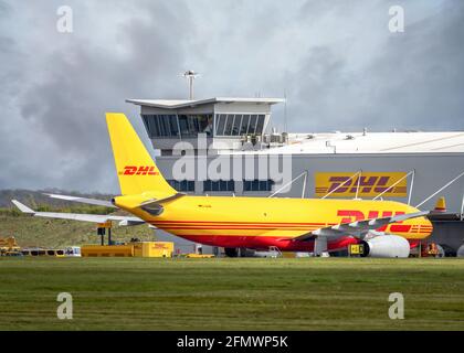 DHL aircraft cargo distribution centre at East Midlands Airport, Leicestershire Yellow Boeing 767 Aeroplane jumbo jet being loaded with packages Stock Photo