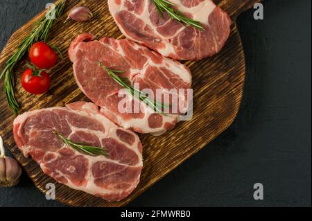 Pork neck raw meat for fresh Chop steaks on wooden cutting board. Top view Stock Photo