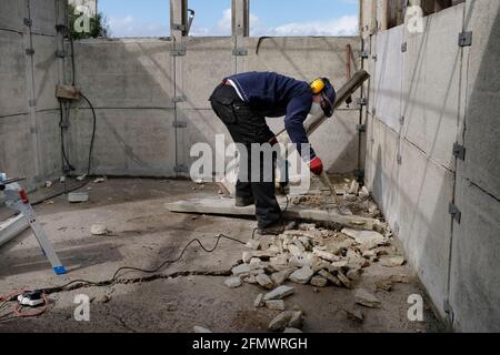A man dismantling his old garage. Stock Photo
