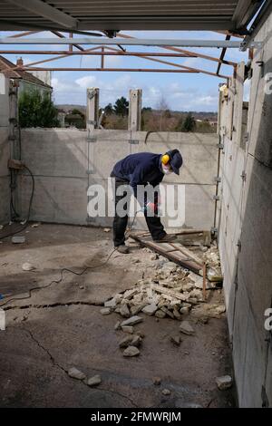 A man dismantling his old garage. Stock Photo