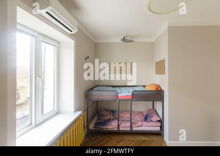 Fragment of modern home interior with bunk bed placed in niche near window in contemporary small apartment with minimalist style design. Children's ro Stock Photo