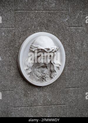 The image of the head of Jesus Christ on a concrete headstone in a cemetery Stock Photo